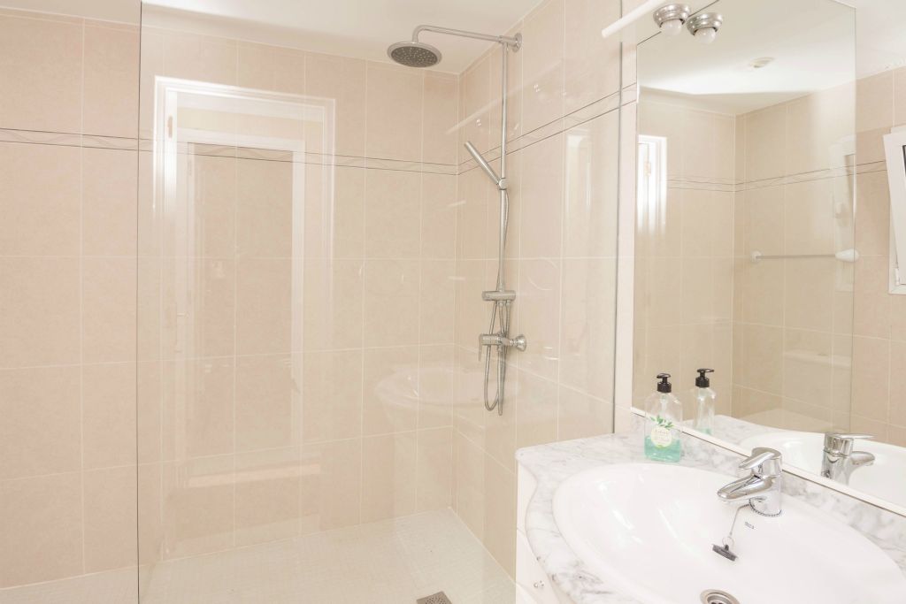 The bathroom contains an Italian shower, toilet and wash-basin.