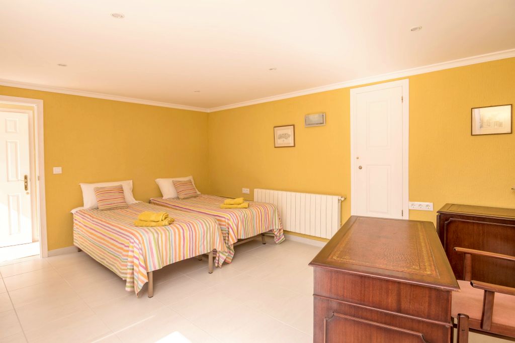 The yellow room has two beds of 90x200, one built-in cupboard and a storage room, as well as a writing desk and chair.