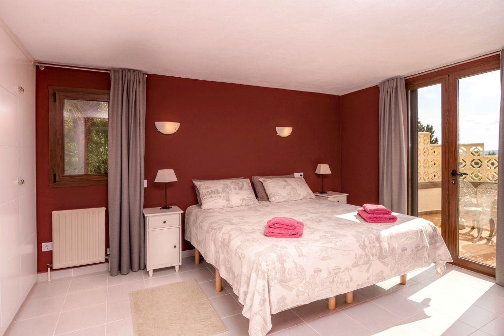 The ensuite master bedroom contains a 180 x 200 bed, four built-in cupboards and a wooden cabinet. With outside shutters, opaque curtains, airconditioning and straight acces to the upper terrace.